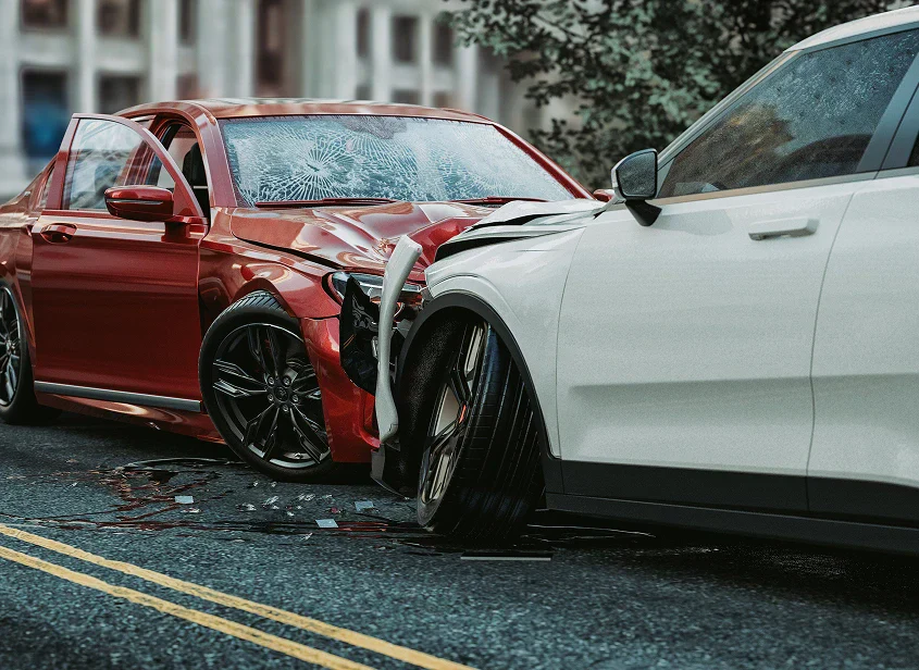 A red sedan and a white SUV are collided on the street, with visible damage and broken glass on the red car's windshield.