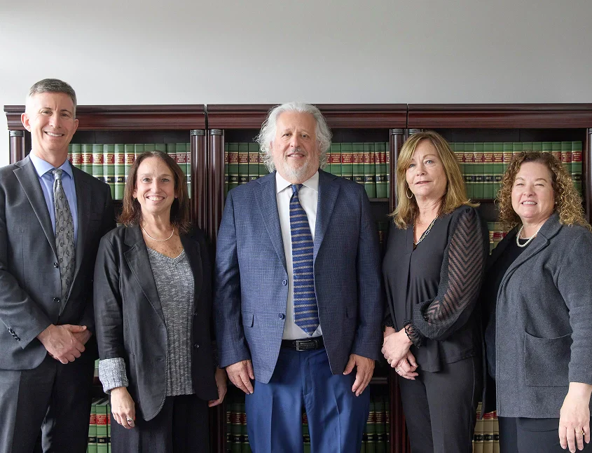 A lawyer and a client sit at a desk, hands clasped in support, with a gavel and legal documents visible, symbolizing trust and collaboration.